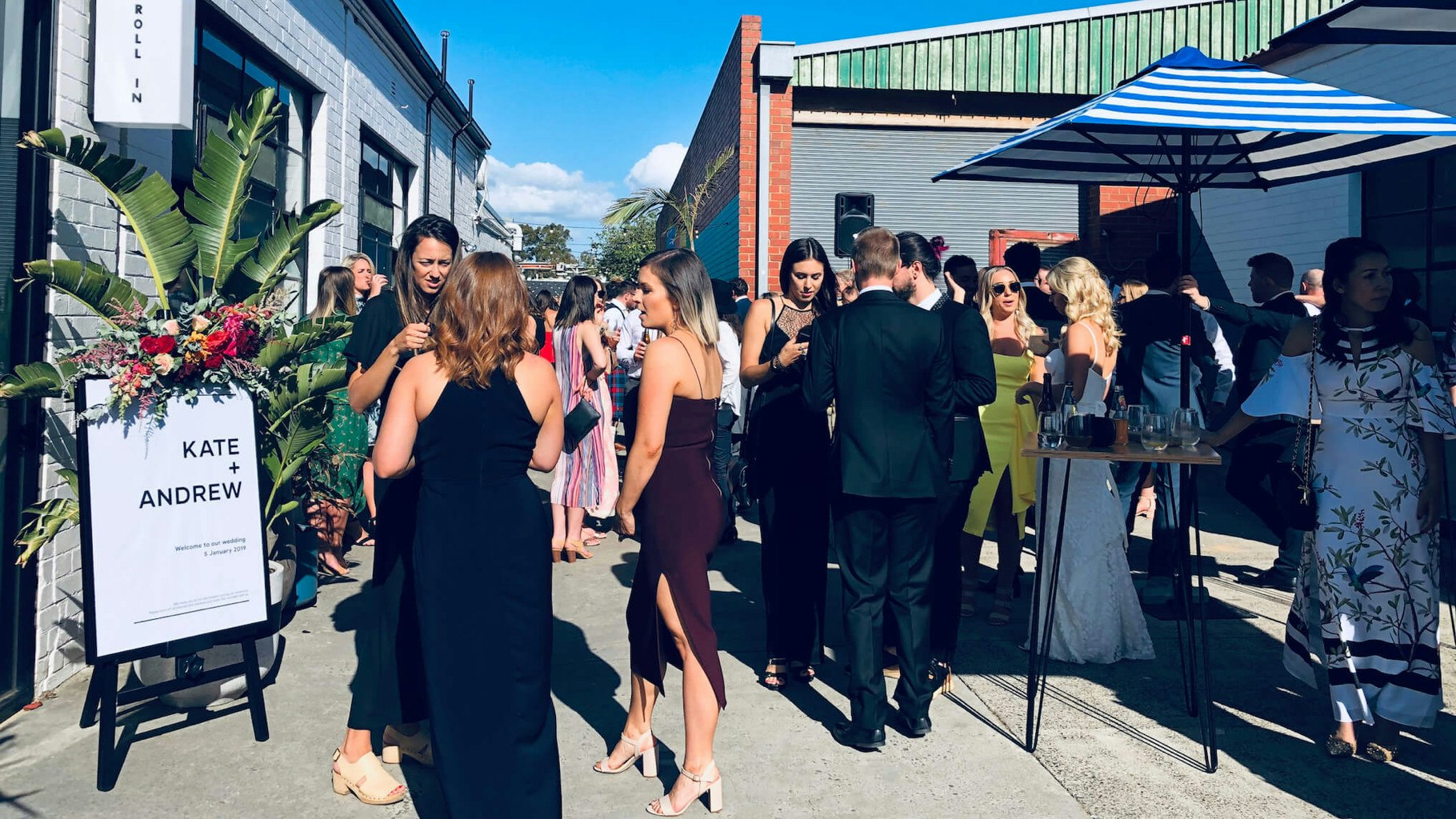 Wedding guests gather in an outdoor courtyard.